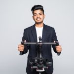 professional indian man videographer with gimball video slr ronin isolated on studio background